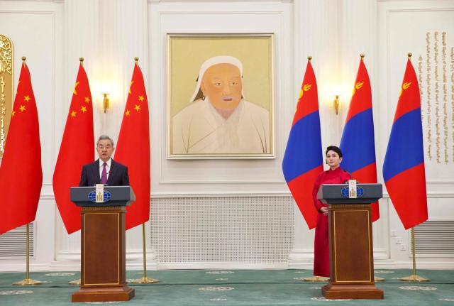 China's Minister of Foreign Affairs Wang Yi (L) speaks next to Mongolia's Minister of Foreign Affairs Batmunkh Battsetseg (R) during a press conference after a bilateral meeting in Ulaanbaatar on June 13, 2026. (Photo by BYAMBASUREN BYAMBA-OCHIR / AFP)