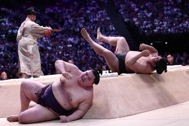Japanese sumo wrestler Oho (L) battles Japanese sumo wrestler Wakamotoharu during their bout on day 1 of the 2026 MUFG Paris Sumo Tournament, in Paris on June 13, 2026. (Photo by Behrouz MEHRI / AFP)