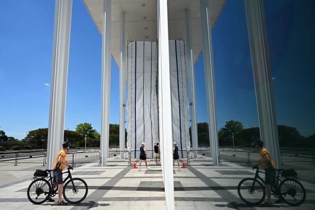 A tarp covers the facade of the John F. Kennedy Memorial Center for the Performing Arts in Washington, DC, on June 13, 2026. Workers began removing President Donald Trump's name from the facade of the John F. Kennedy Center for the Performing Arts on Saturday, after a federal judge ruled that its renaming was unlawful. The effort came after a judge rejected a last-minute bid by the center's board to halt the removal of Trump's name. (Photo by Alex WROBLEWSKI / AFP)