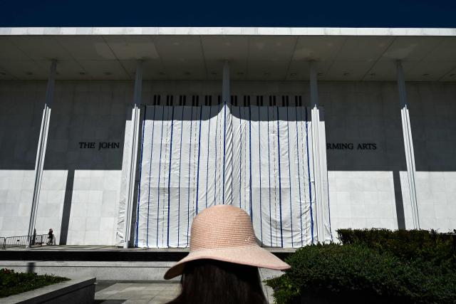 A tarp covers the facade of the John F. Kennedy Memorial Center for the Performing Arts in Washington, DC, on June 13, 2026. Workers began removing President Donald Trump's name from the facade of the John F. Kennedy Center for the Performing Arts on Saturday, after a federal judge ruled that its renaming was unlawful. The effort came after a judge rejected a last-minute bid by the center's board to halt the removal of Trump's name. (Photo by Alex WROBLEWSKI / AFP)