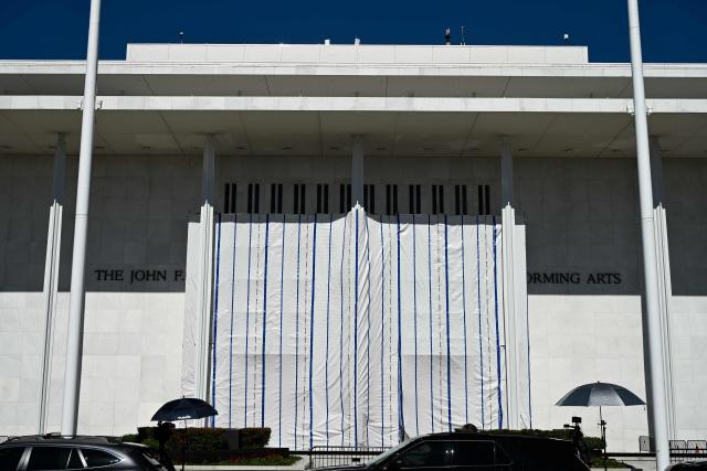 A tarp covers the facade of the John F. Kennedy Memorial Center for the Performing Arts in Washington, DC, on June 13, 2026. Workers began removing President Donald Trump's name from the facade of the John F. Kennedy Center for the Performing Arts on Saturday, after a federal judge ruled that its renaming was unlawful. The effort came after a judge rejected a last-minute bid by the center's board to halt the removal of Trump's name. (Photo by Alex WROBLEWSKI / AFP)