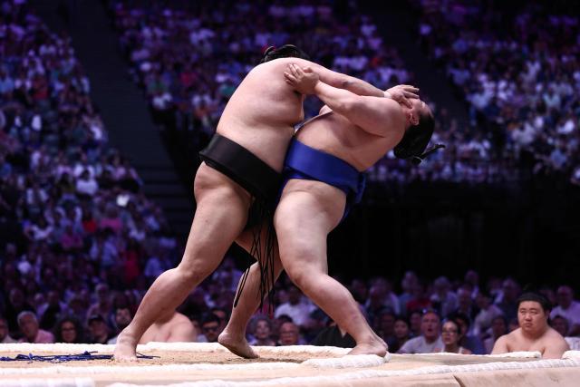 Japanese sumo wrestler Abi (L) battles Japanese sumo wrestler Kotoshoho during a bout on day 1 of the 2026 MUFG Paris Sumo Tournament, in Paris on June 13, 2026. (Photo by Behrouz MEHRI / AFP)