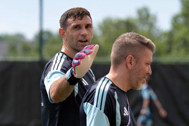 Argentina's goalkeeper #23 Emiliano Martinez (L) arrives with physiotherapist Pablo Capuchetti (R) to take part in a training session ahead of Argentina's 2026 World Cup football tournament Group J football match against Algeria in Kansas City on June 13, 2026.  (Photo by JUAN MABROMATA / AFP)