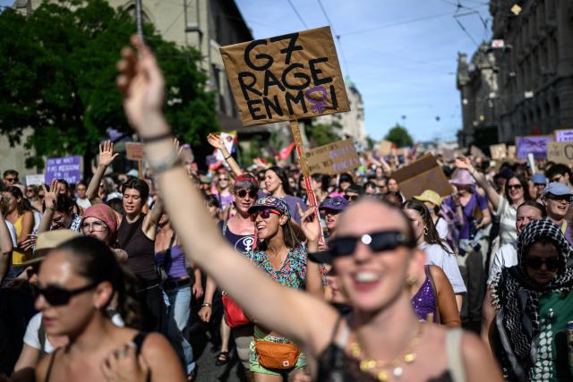 A protester holds a placard reading "G7: rage inside me" during a feminist strike against patriarchy and the upcoming G7 summit in nearby Evian, in Lausanne on June 13, 2026. (Photo by Fabrice COFFRINI / AFP)