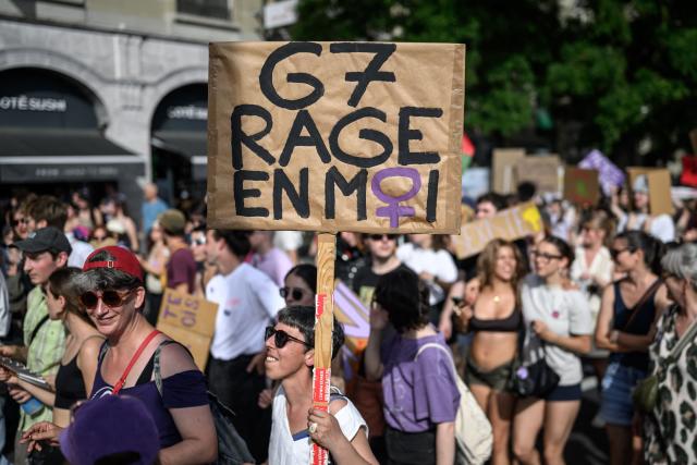 A protester holds a placard reading "G7: rage inside me" during a feminist strike against patriarchy and the upcoming G7 summit in nearby Evian, in Lausanne on June 13, 2026. (Photo by Fabrice COFFRINI / AFP)