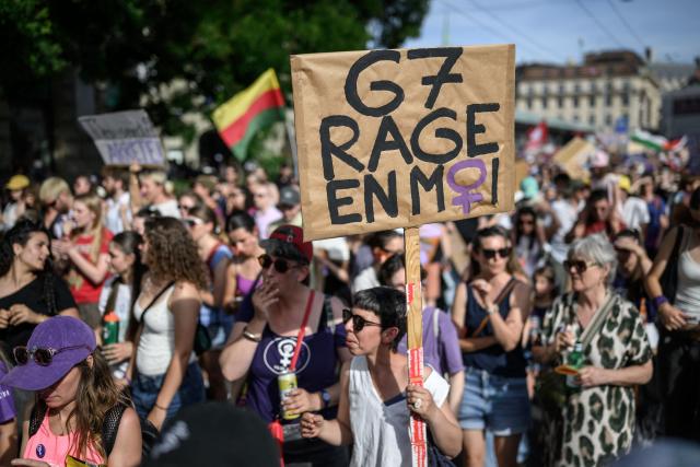 TOPSHOT - A protester holds a placard reading "G7: rage inside me" during a feminist strike against patriarchy and the upcoming G7 summit in nearby Evian, in Lausanne on June 13, 2026. (Photo by Fabrice COFFRINI / AFP)