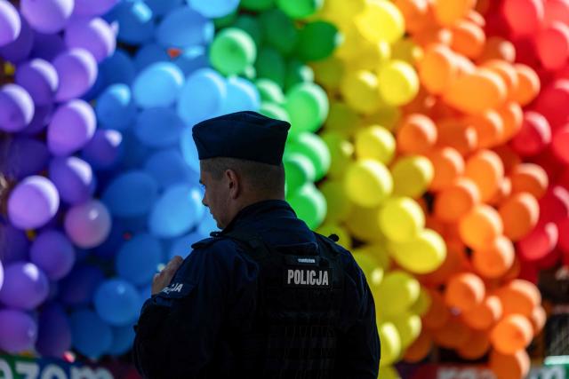A Police officer stands in front of a rainbow balloons decorations during the Warsaw Pride parade in the streets of Warsaw, Poland, on June 13, 2026. (Photo by Wojtek RADWANSKI / AFP)