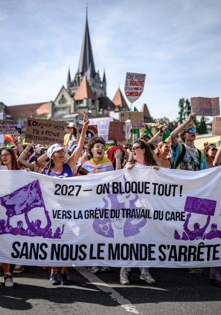 Protesters hold a banner reading "2027 - we block everything; without us the world stops" as they take part in a feminist strike against patriarchy and the upcoming G7 summit in nearby Evian, in Lausanne on June 13, 2026. (Photo by Fabrice COFFRINI / AFP)