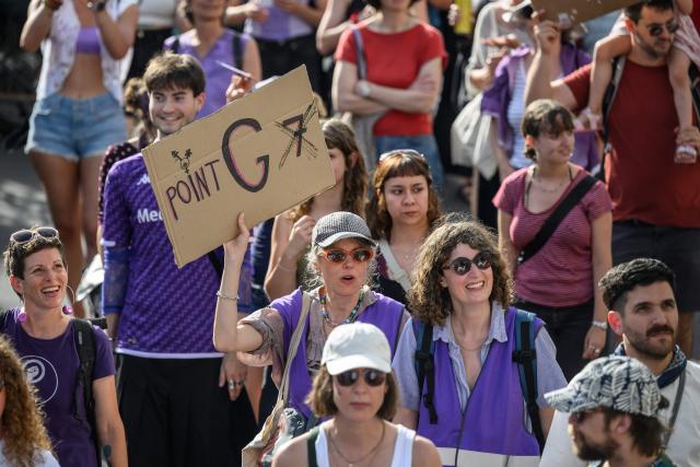 A protester holds a placard reading "G spot 7" during a feminist strike against patriarchy and the upcoming G7 summit in nearby Evian, in Lausanne on June 13, 2026. (Photo by Fabrice COFFRINI / AFP)
