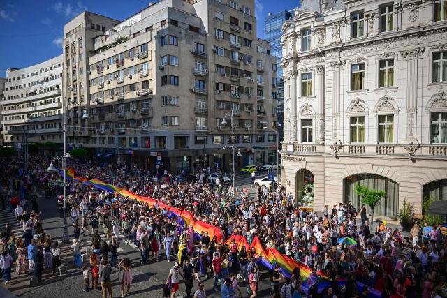 People take part in Bucharest Pride march in Bucharest June 13, 2026. Tens of thousands of participants march with rainbow flags down Calea Victoriei during the 21st annual Bucharest Pride march, demanding equal rights and legal recognition for same-sex couples in Romania. (Photo by Daniel MIHAILESCU / AFP)