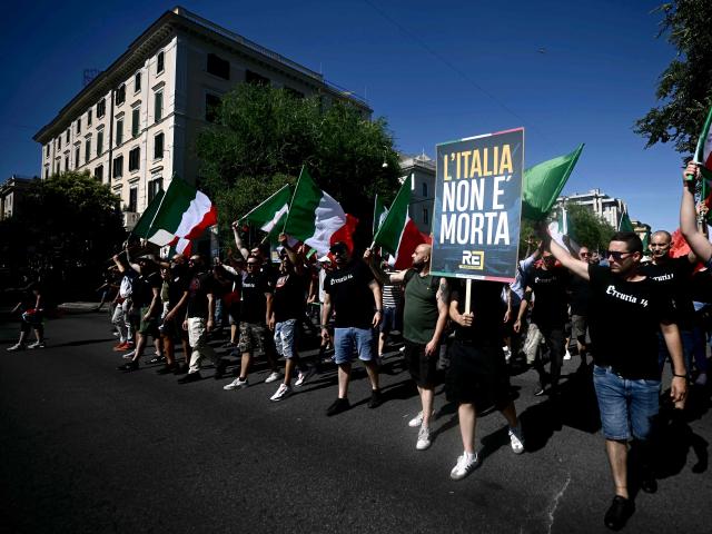 A demonstrator holds a placard reading "Italy is not dead" during a protest organised by right-wing groups to call for the repatriation of migrants, in Rome on June 13, 2026. (Photo by Filippo MONTEFORTE / AFP)