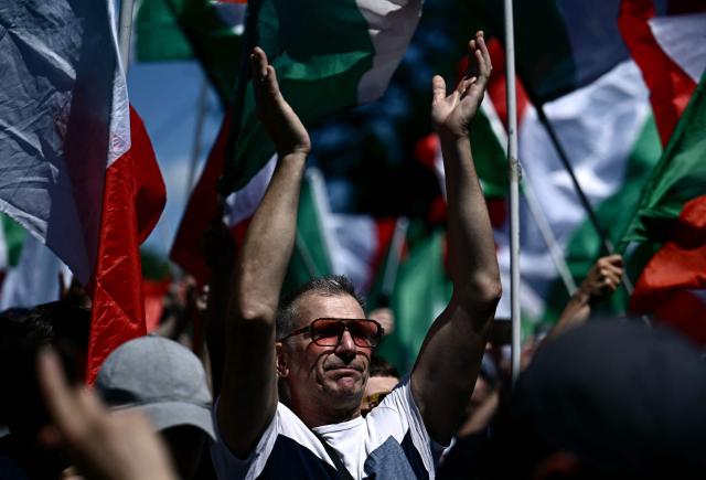 A demonstrator applauds during a protest organised by right-wing groups to call for the repatriation of migrants, in Rome on June 13, 2026. (Photo by Filippo MONTEFORTE / AFP)
