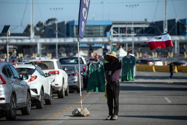 A street vendor sells Mexican jerseys and flags to people crossing to the United States at the San Ysidro border crossing on the Mexican side of the border in Tijuana on June 13, 2026. (Photo by Guillermo Arias / AFP)