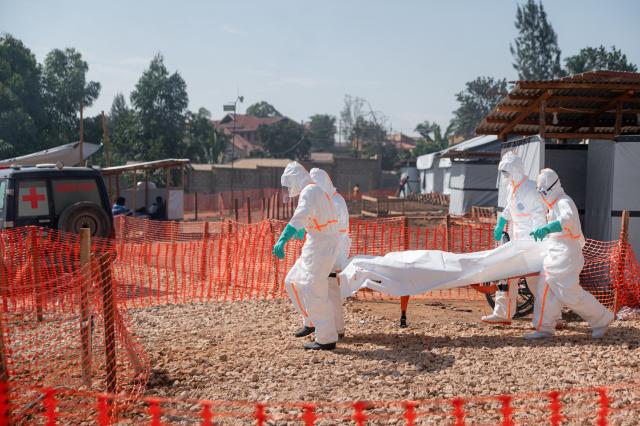 EDITORS NOTE: Graphic content / Members of specialized response teams carry to the morgue of the Evangelical Medical Center of Nyankunde (CME) the body of a person who died from Ebola virus disease to allow relatives to pay their last respects after washing, disinfection and safe body-wrapping procedures in Bunia, Ituri Province, Democratic Republic of Congo, on June 13, 2026. (Photo by Jospin Mwisha / AFP)
