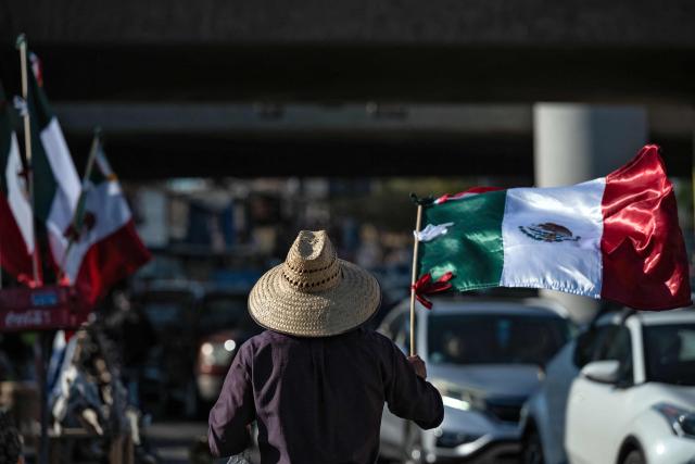 Street vendors sell Mexican jerseys and flags at the San Ysidro crossing port on the Mexican side of the border in Tijuana on June 13, 2026. (Photo by Guillermo Arias / AFP)