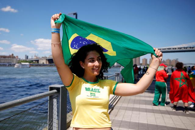 A woman holds a Brazilian flag ahead of a watch party for the 2026 World Cup football tournament match between Brazil and Morocco, at the FIFA Fan Zone in the Brooklyn borough of New York City, on June 13, 2026. (Photo by Leonardo MUNOZ / AFP)