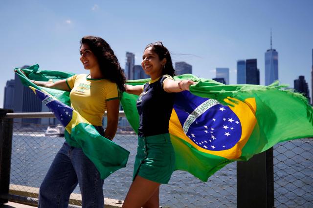 Women hold Brazilian flags ahead of a watch party for the 2026 World Cup football tournament match between Brazil and Morocco, at the FIFA Fan Zone in the Brooklyn borough of New York City, on June 13, 2026. (Photo by Leonardo MUNOZ / AFP)