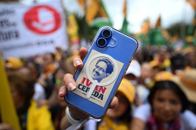 A supporter of Colombia's presidential candidate for the Pacto Historico party Ivan Cepeda, holds a mobile phone with his picture during the closing rally of his campaign in Bogota on June 13, 2026. Colombia will hold the runoff presidential election on June 21. (Photo by Juan BARRETO / AFP)