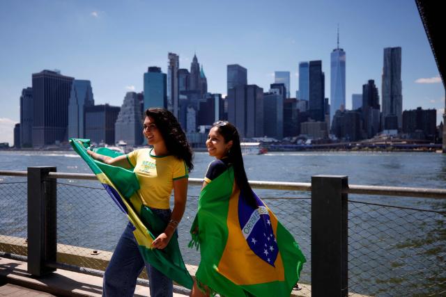 Women hold Brazilian flags ahead of a watch party for the 2026 World Cup football tournament match between Brazil and Morocco, at the FIFA Fan Zone in the Brooklyn borough of New York City, on June 13, 2026. (Photo by Leonardo MUNOZ / AFP)