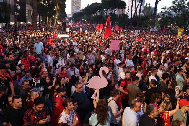 Protestors hold national flags as they gather in front of Albania's Prime Minister's Office, in Tirana, on June 13, 2026 during a demonstration against the construction of a luxury resort near a protected natural area of Zvernec near Vlore. Several thousand citizens demonstrated in Tirana, 14 days in row after the first protest  repressed on Zvernec beach, to demand transparency around a tourist complex project allegedly linked to US President's son-in-law, Jared Kushner. The demonstrators argue that the estimated $1.2 billion project, led by Kushner and his wife Ivanka, will harm the environment, with plans for luxury hotels in the protected area of Vjosa-Narta on the southern coast. (Photo by Adnan Beci / AFP)