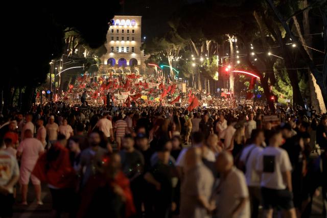 Protestors hold national flags as they gather in front of Albania's Prime Minister's Office, in Tirana, on June 13, 2026 during a demonstration against the construction of a luxury resort near a protected natural area of Zvernec near Vlore. Several thousand citizens demonstrated in Tirana, 14 days in row after the first protest  repressed on Zvernec beach, to demand transparency around a tourist complex project allegedly linked to US President's son-in-law, Jared Kushner. The demonstrators argue that the estimated $1.2 billion project, led by Kushner and his wife Ivanka, will harm the environment, with plans for luxury hotels in the protected area of Vjosa-Narta on the southern coast. (Photo by Adnan Beci / AFP)