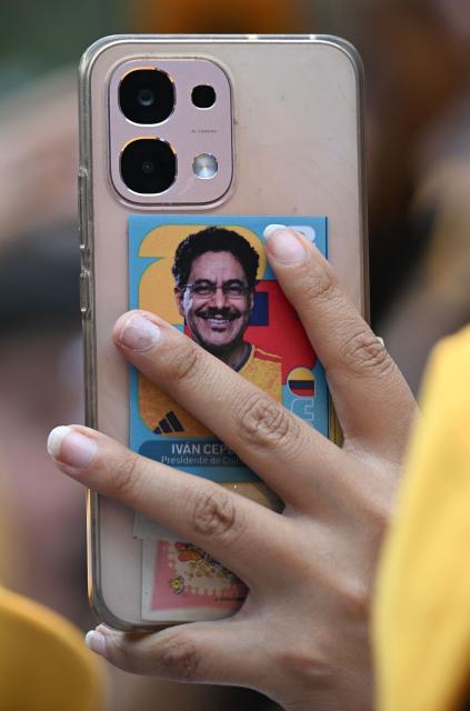 A supporter of Colombia's presidential candidate for the Pacto Historico party Ivan Cepeda, holds a mobile phone with his picture during the closing rally of his campaign in Bogota on June 13, 2026. Colombia will hold the runoff presidential election on June 21. (Photo by Juan BARRETO / AFP)