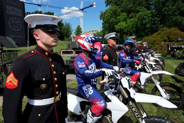 Stunt performers line up next to members of the US military after performing a motorcylcle jump, ahead of Sunday's UFC Freedom 250 fights on the South Lawn of the White House in Washington, DC, on June 13, 2026. (Photo by Alex Brandon / POOL / AFP)