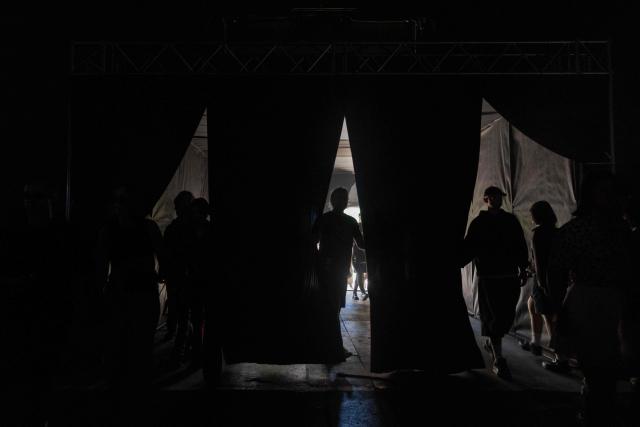 Festival-goers walk near the entrance during "BRUDNY PES" (dirty dog), a multi-genre music festival independent music and street culture, at the Dovzhenko Film Studio in Kyiv on June 13, 2026, amid the Russian invasion of Ukraine. The festival will raffle off a car for donations in support of the Armed Forces of Ukraine. All funds raised will go toward purchasing drones. Since 2023, the festival has partnered with the "Khvostati" animal shelter, selecting a new dog each year to serve as the festivals mascot. Its photo is featured on the main poster, and seeks to find it a home. (Photo by Tetiana DZHAFAROVA / AFP)