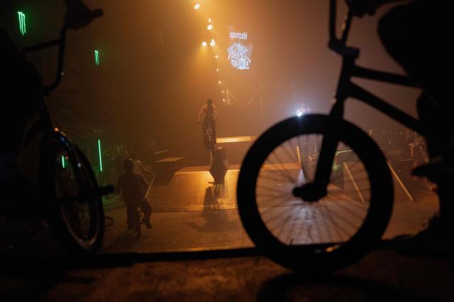 Young men perform bike tricks during "BRUDNY PES" (dirty dog), a multi-genre music festival independent music and street culture, at the Dovzhenko Film Studio in Kyiv on June 13, 2026, amid the Russian invasion of Ukraine. The festival will raffle off a car for donations in support of the Armed Forces of Ukraine. All funds raised will go toward purchasing drones. Since 2023, the festival has partnered with the "Khvostati" animal shelter, selecting a new dog each year to serve as the festivals mascot. Its photo is featured on the main poster, and seeks to find it a home. (Photo by Tetiana DZHAFAROVA / AFP)