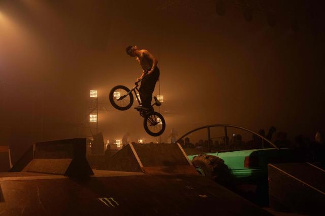 A youmg man performs bike tricks during "BRUDNY PES" (dirty dog), a multi-genre music festival independent music and street culture, at the Dovzhenko Film Studio in Kyiv on June 13, 2026, amid the Russian invasion of Ukraine. The festival will raffle off a car for donations in support of the Armed Forces of Ukraine. All funds raised will go toward purchasing drones. Since 2023, the festival has partnered with the "Khvostati" animal shelter, selecting a new dog each year to serve as the festivals mascot. Its photo is featured on the main poster, and seeks to find it a home. (Photo by Tetiana DZHAFAROVA / AFP)