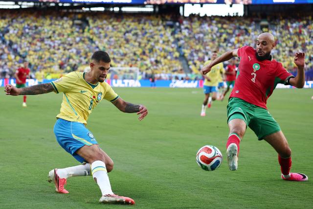 Brazil's midfielder #08 Bruno Guimaraes kicks the ball past Morocco's defender #03 Noussair Mazraoui during the 2026 World Cup Group C football match between Brazil and Morocco at the New York/New Jersey Stadium in East Rutherford on June 13, 2026. (Photo by CHARLY TRIBALLEAU / AFP)