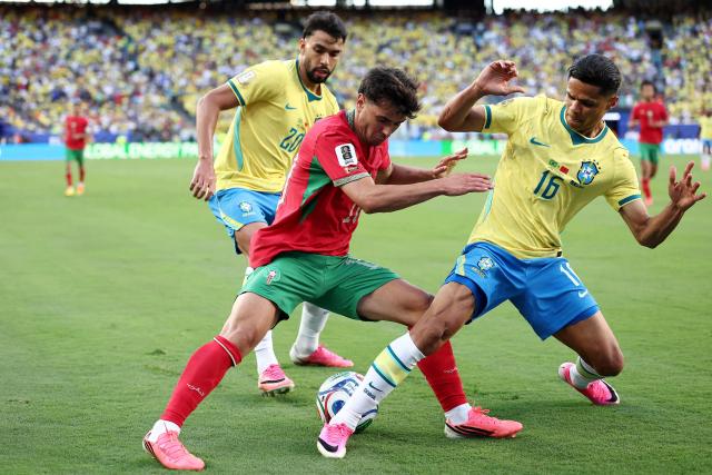 Brazil's midfielder #20 Lucas Paqueta (L), Morocco's forward #10 Brahim Diaz (C), and Brazil's defender #16 Douglas Santos (R) fight for the ball during the 2026 World Cup Group C football match between Brazil and Morocco at the New York/New Jersey Stadium in East Rutherford on June 13, 2026. (Photo by CHARLY TRIBALLEAU / AFP)