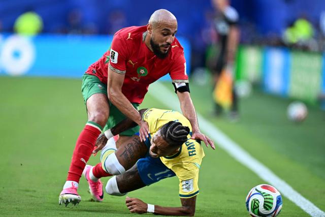 Morocco's defender #03 Noussair Mazraoui and Brazil's forward #11 Raphinha fight for the ball during the 2026 World Cup Group C football match between Brazil and Morocco at the New York/New Jersey Stadium in East Rutherford on June 13, 2026. (Photo by Jewel SAMAD / AFP)