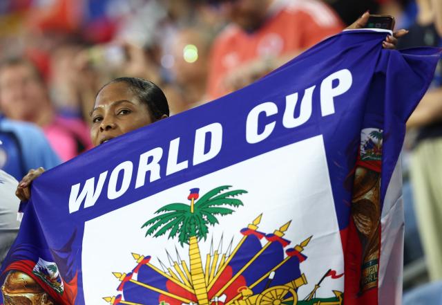A Haiti fan holds up a flag ahead of the 2026 World Cup Group C football match between Haiti and Scotland at the Boston Stadium in Foxborough on June 13, 2026. (Photo by FRANCK FIFE / AFP)