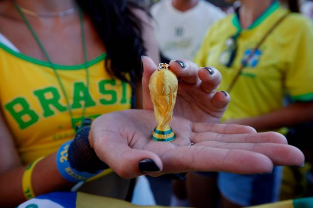 A Brazil fan displays a World Cup trophy keychain during a watch party during the 2026 World Cup football tournament match between Brazil and Morocco at the FIFA Fan Zone in Brooklyn, New York, on June 13, 2026. (Photo by Leonardo MUNOZ / AFP)