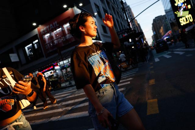 A Knicks fan walks near Madison Square Garden before Game 5 of the NBA finals between the New York Knicks and San Antonio Spurs, in New York, on June 13, 2026. (Photo by kena betancur / AFP)
