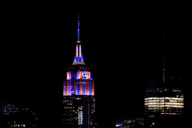 The Empire State Building is lit with the colors of New York Knicks after the New York Knicks defeated the San Antonio Spurs in Game 5 of the NBA Finals to win the series, as seen from West New York, New Jersey, on June 13, 2026. The Knicks won the NBA Championship for the first time since 1973, for the third time in franchise history. (Photo by Leonardo MUNOZ / AFP)