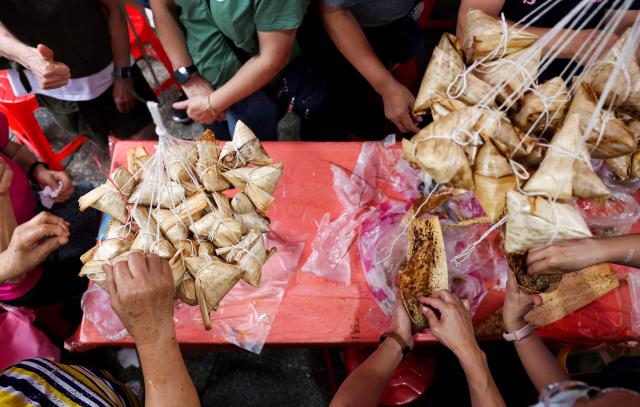People make traditional rice dumplings ahead of the annual Dragon Boat Festival in New Taipei City on June 14, 2026. (Photo by I-Hwa Cheng / AFP)