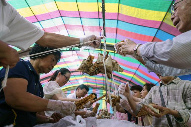 People make traditional rice dumplings ahead of the annual Dragon Boat Festival in New Taipei City on June 14, 2026. (Photo by I-Hwa Cheng / AFP)