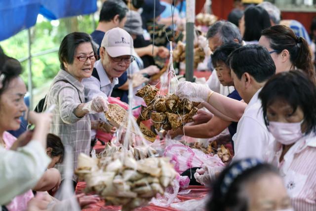 People make traditional rice dumplings ahead of the annual Dragon Boat Festival in New Taipei City on June 14, 2026. (Photo by I-Hwa Cheng / AFP)