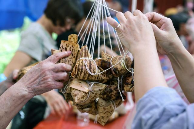 People make traditional rice dumplings ahead of the annual Dragon Boat Festival in New Taipei City on June 14, 2026. (Photo by I-Hwa Cheng / AFP)