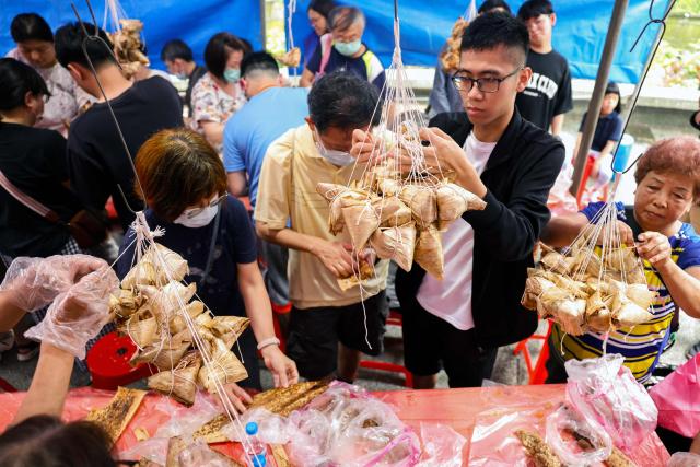 People make traditional rice dumplings ahead of the annual Dragon Boat Festival in New Taipei City on June 14, 2026. (Photo by I-Hwa Cheng / AFP)