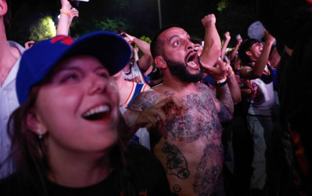 Knicks fans celebrate in Central Park after the New York Knicks defeated the San Antonio Spurs in Game 5 of the NBA Finals to win the series, in New York, on June 13, 2026. The Knicks won the NBA Championship for the first time since 1973, for the third time in franchise history. (Photo by kena betancur / AFP)