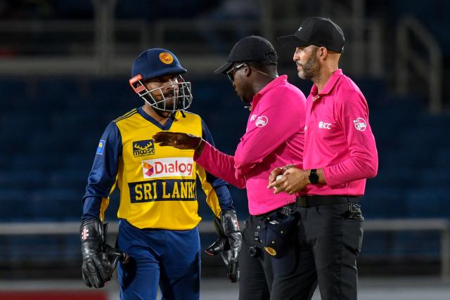 Umpires Leslie Reifer Jr (2R) and Christopher Taylor (R) talk to Kusal Mendis (L) of Sri Lanka about Shimron Hetmyer of West Indies not out decision during the second Twenty20 (T20) international cricket match between West Indies and Sri Lanka at Sabina Park in Kingston, Jamaica, on June 13, 2026. (Photo by Randy Brooks / AFP)