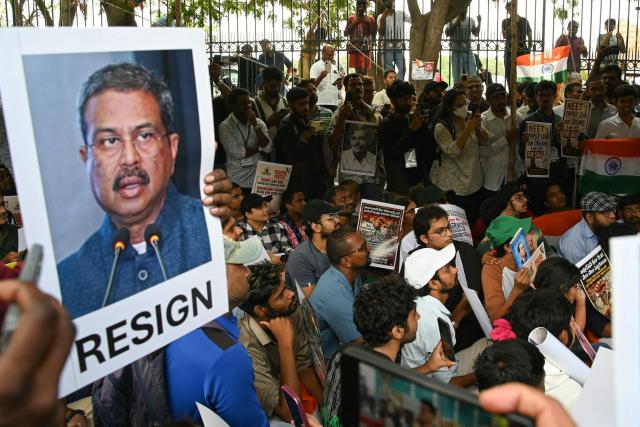 Cockroach Janata Party (CJP) activists a hold placard featuring India's Education Minister Dharmendra Pradhan during a protest over alleged irregularities in the country’s major examinations in Hyderabad on June 14, 2026. (Photo by Noah SEELAM / AFP)