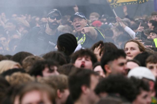 Police watch the crowd as football fans react to a broadcast of the FIFA World Cup 2026 Group D match between Australia and Turkey on a giant screen during a public viewing event at Federation Square in Melbourne on June 14, 2026. (Photo by WILLIAM WEST / AFP)