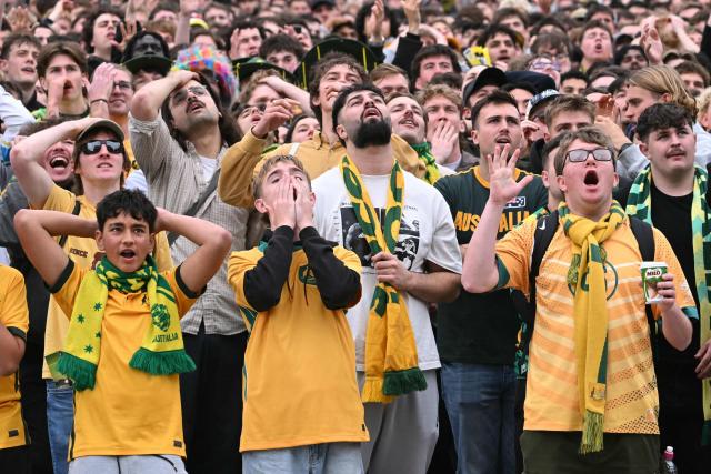 Football fans react as they watch a broadcast of the FIFA World Cup 2026 Group D match between Australia and Turkey on a giant screen during a public viewing event at Federation Square in Melbourne on June 14, 2026. (Photo by WILLIAM WEST / AFP)
