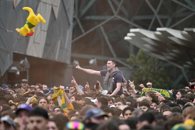 Football fans react as they watch a broadcast of the FIFA World Cup 2026 Group D match between Australia and Turkey on a giant screen during a public viewing event at Federation Square in Melbourne on June 14, 2026. (Photo by WILLIAM WEST / AFP)