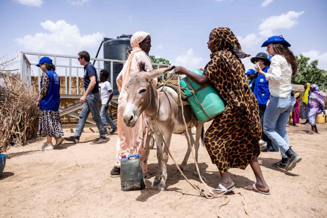 Two women load water cannisters onto a donkey at the Tongori camp on June 9, 2026. Rising numbers of Chadians fleeing the Sudan war are arriving at the Adre border post in Chad, but funding shortages could force UN agencies on the ground to stop operating.
The civil conflict in Sudan has already cost tends of thousands of lives and forced more than 12 million people to flee their homes, more a million of them Chadian, according to UN figures. (Photo by Joris Bolomey / AFP)