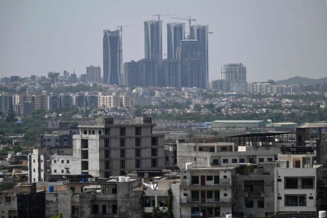 Cranes operate next to newly constructed high-rise buildings on the outskirts of Islamabad on June 14, 2026. Pakistan's government presented its annual budget on June 12, including plans to boost tax collection and defence spending, as citizens expressed weariness with surging inflation sparked by the Middle East crisis that Islamabad is mediating to end. (Photo by Aamir QURESHI / AFP)